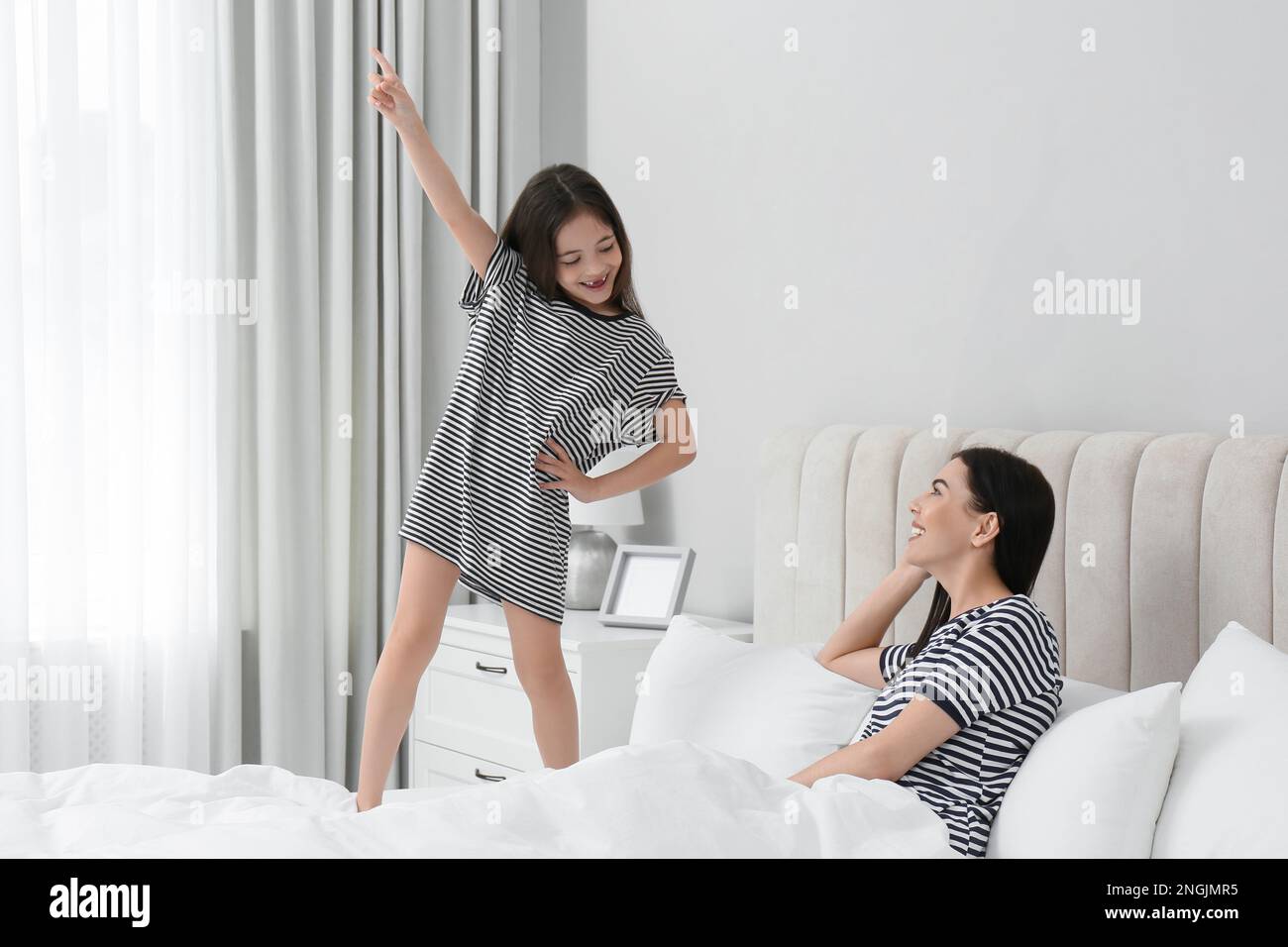 Young mother and her daughter having fun in bedroom Stock Photo - Alamy