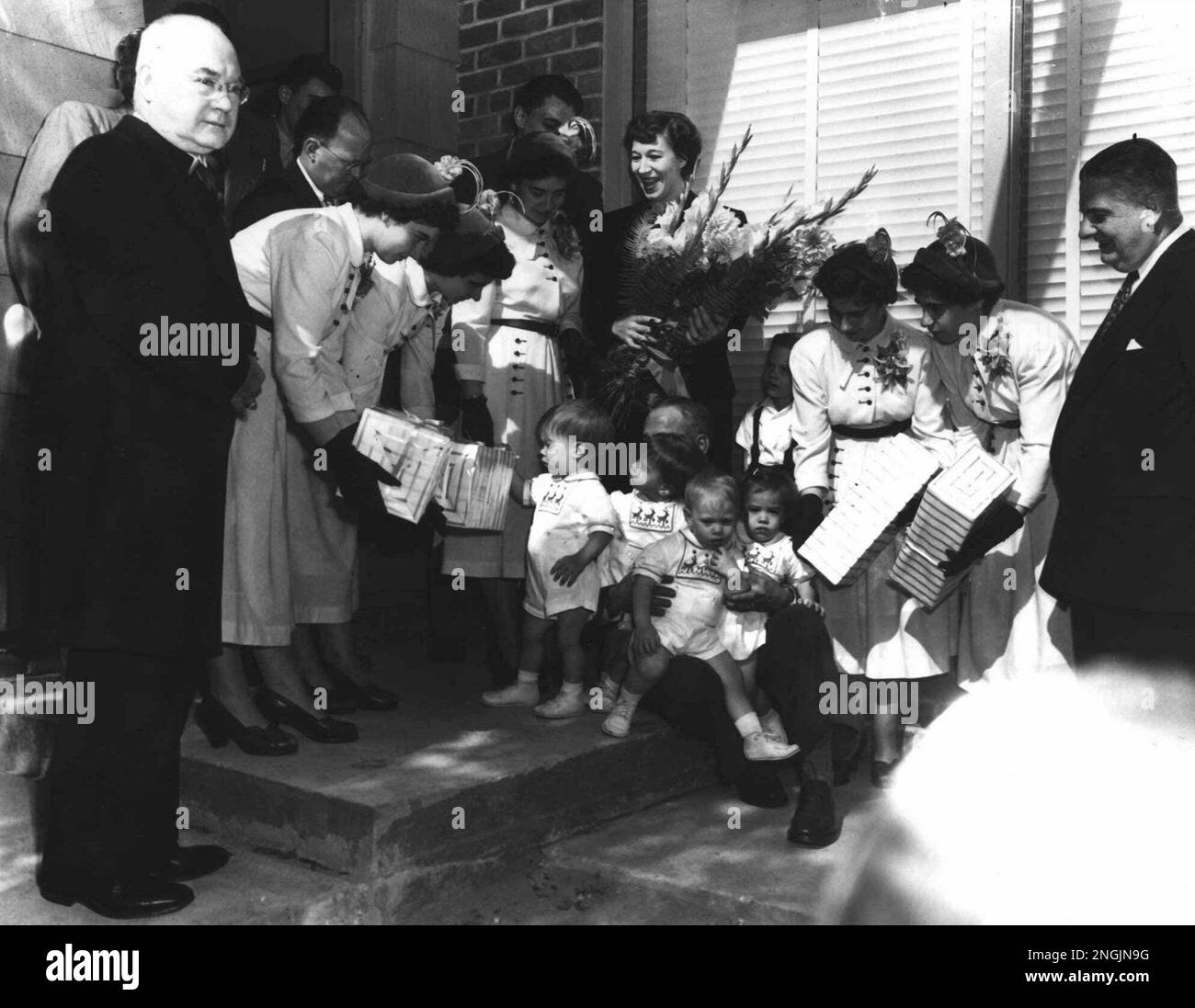 The Dionne Quintuplets present gifts to the Collins quads at their home