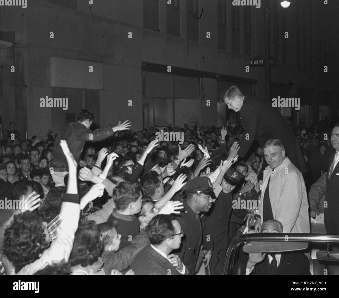 Many people in the crowd are shown reaching out in an attempt to shake ...