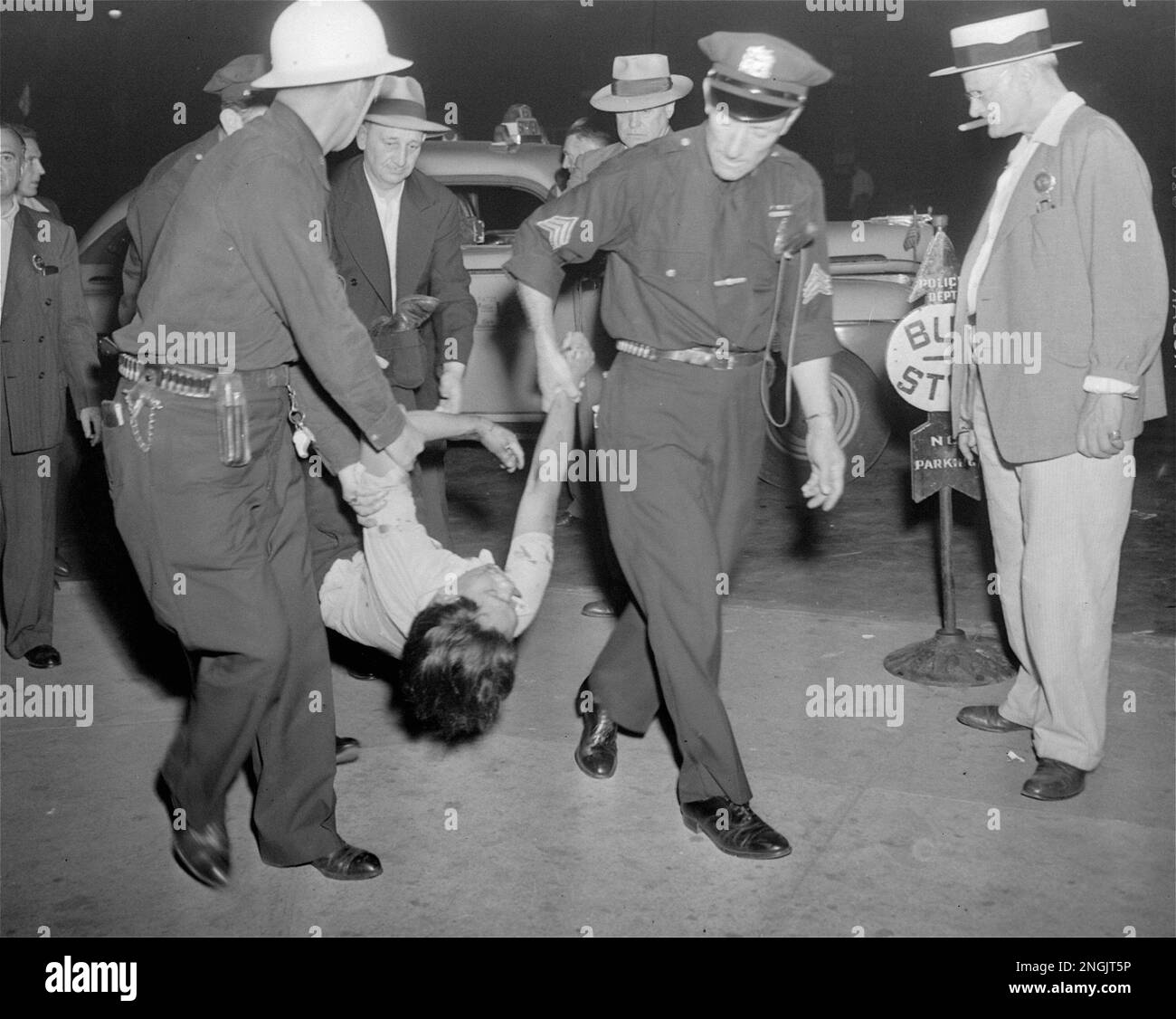 Police carry an injured unidentified man, August 2, 1943, into Sydenham