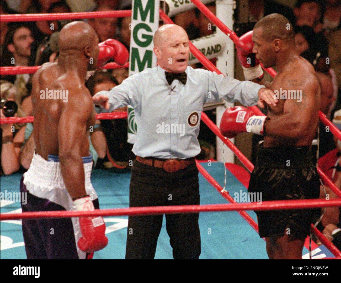 Referee Mills Lane, center, separates WBA heavyeight champion Evander