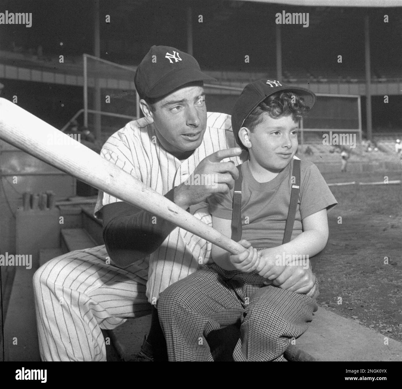 Joe DiMaggio, star Yankee outfielder, passes on a few batting tips to his  five-and-a-half-year old son, Joseph III, prior to the Yankees --  Washington Senators game at Yankee Stadium, New York, April