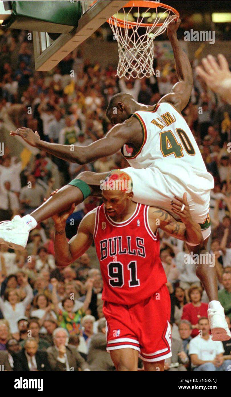 Seattle SuperSonics' Shawn Kemp hangs from the rim after a third