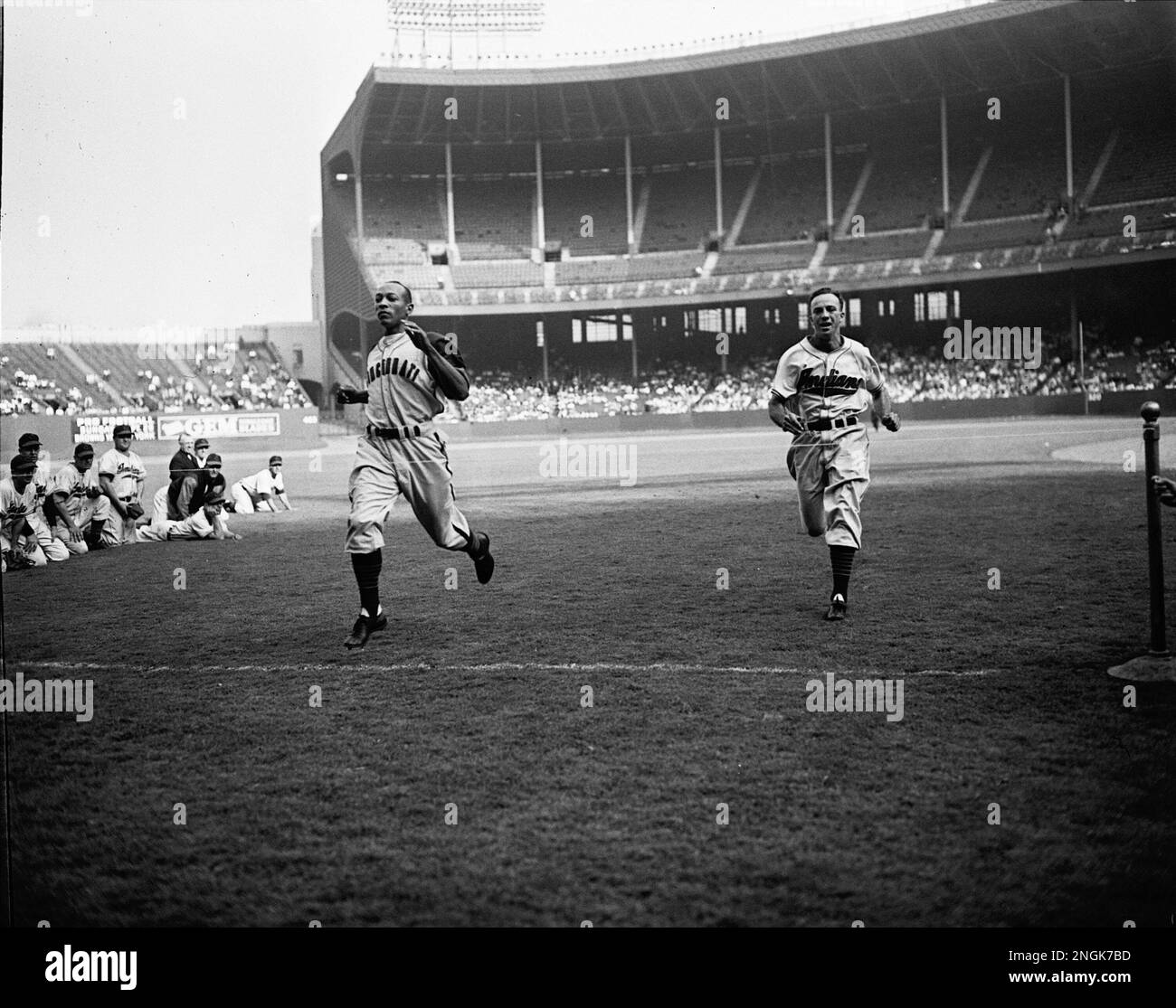 Jesse Owens, left, in baseball togs runs a 100yard dash in 9.9 seconds