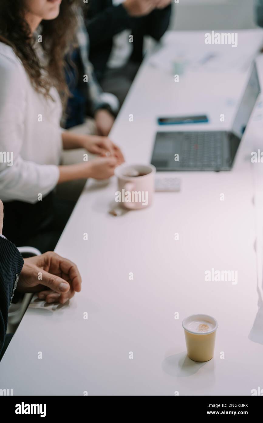 Businesspeople with coffees, teas and lap top on their working desk