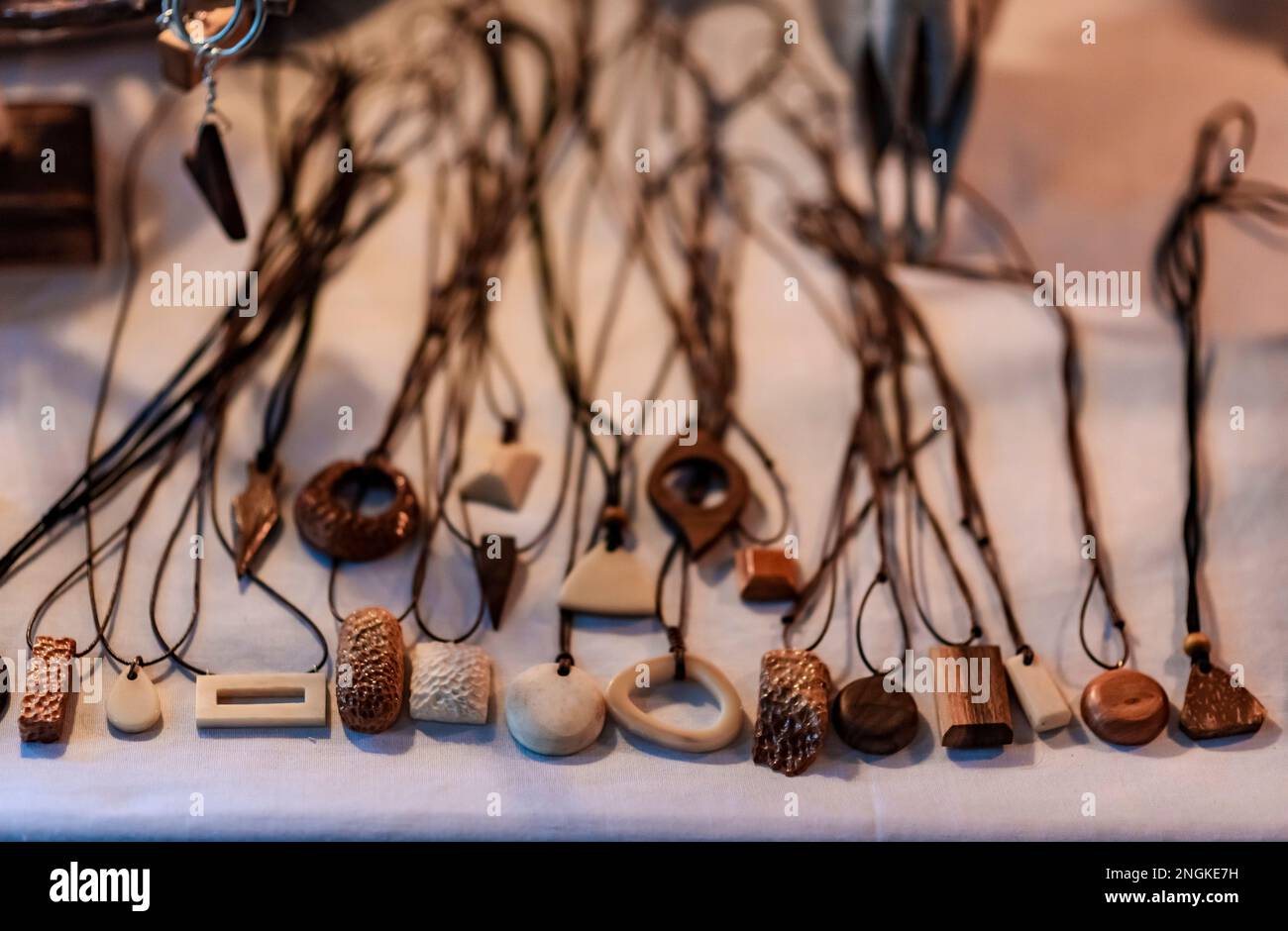 Carved necklaces made of scrap animal bones and woods are seen on