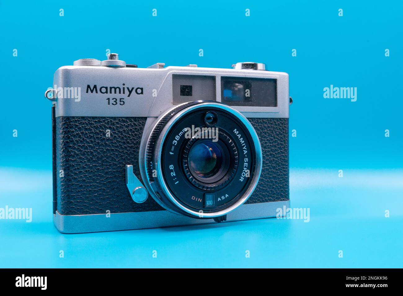 Closeup shot of Mamiya 135 EE rangefinder camera with Mamiya Sekkor 38mm lens on cyan background Stock Photo