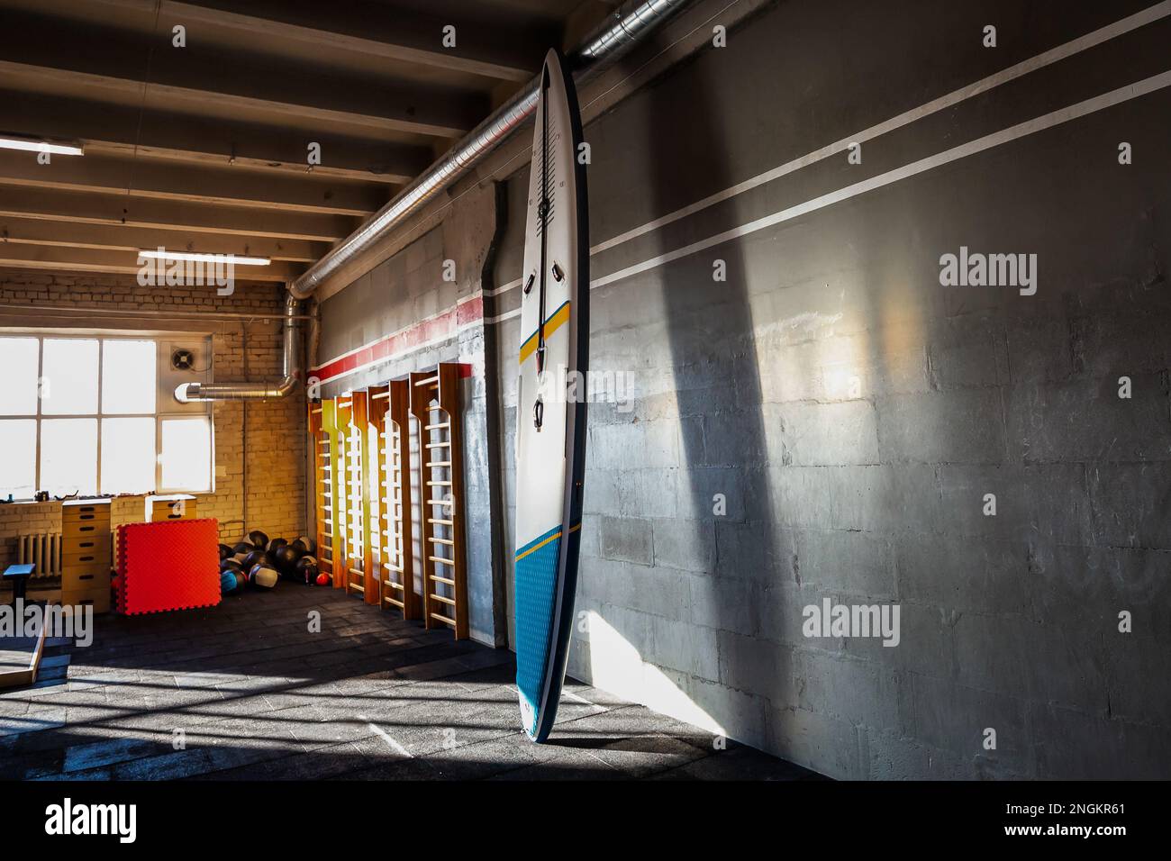 Colorful inflatable stand-up paddle board SUP by the wall. Surfing and ...