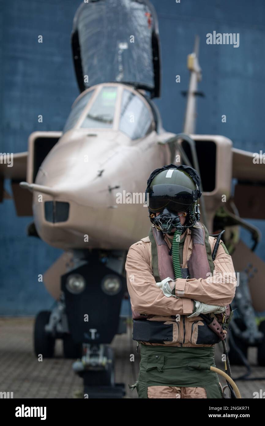 Fighter pilot, RAF, standing with fighter Jet ready for a combat mission wearing flying helmet, suit and dark visor with oxygen mask Royal Air Force. Stock Photo