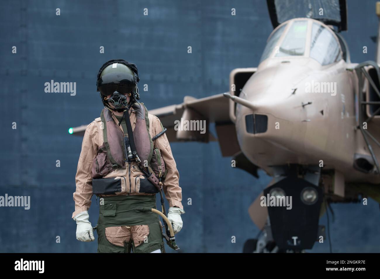 Fighter pilot, RAF, standing with fighter Jet ready for a combat mission wearing flying helmet, suit and dark visor with oxygen mask Royal Air Force. Stock Photo