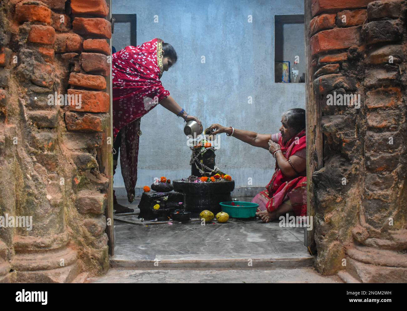 Kolkata, India. 18th Feb, 2023. Hindu devotees pour holy water over a Shivling (a symbol of Lord