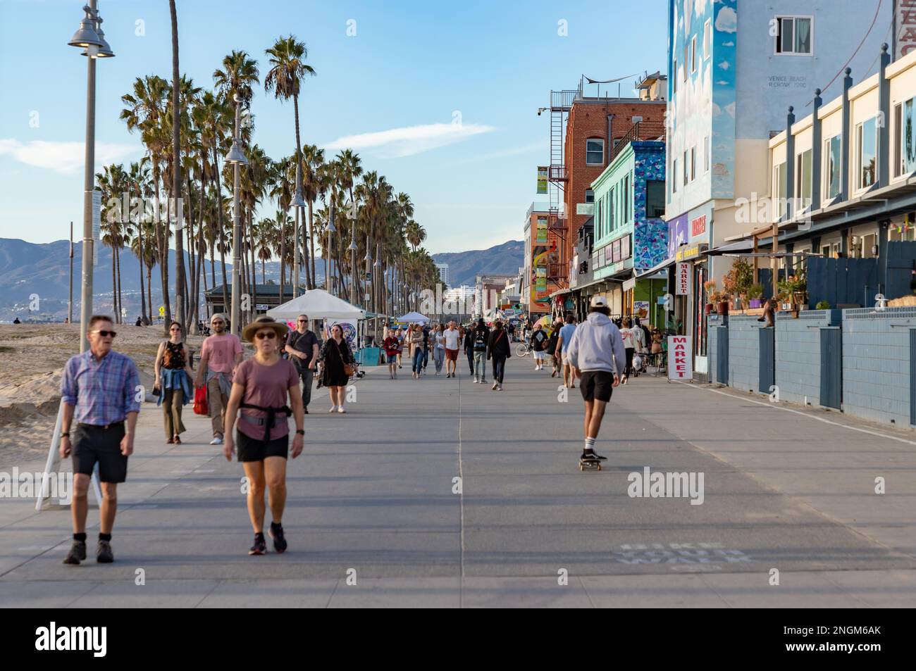 A picture of the iconic Venice Beach boardwalk with people walking on