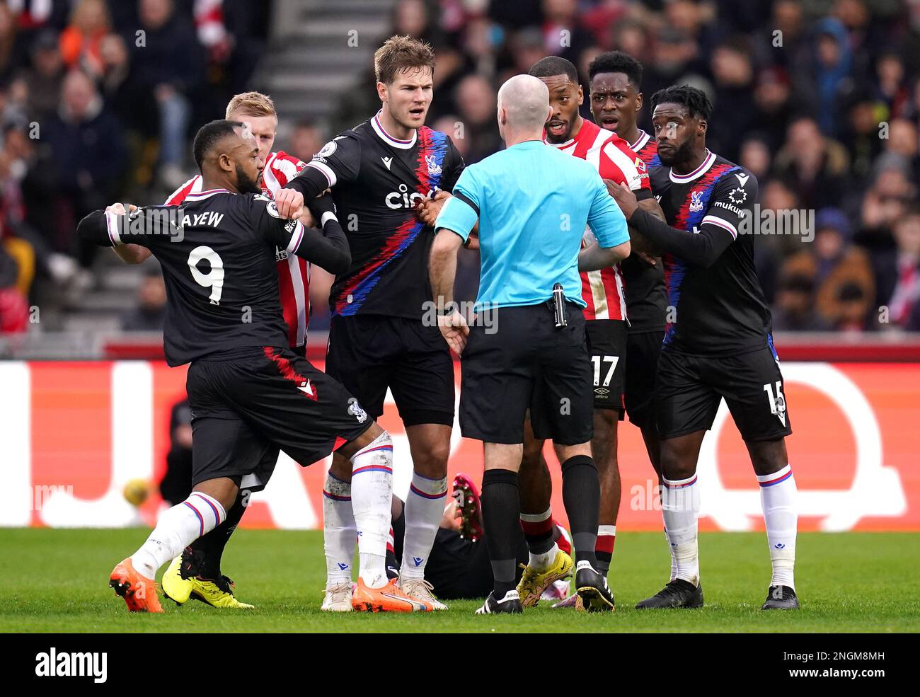 Crystal Palace's Joachim Andersen (centre) and Brentford's Ivan Toney speak with referee Paul Tierney with players around them during the Premier League match at the Gtech Community Stadium, London. Picture date: Saturday February 18, 2023. Stock Photo
