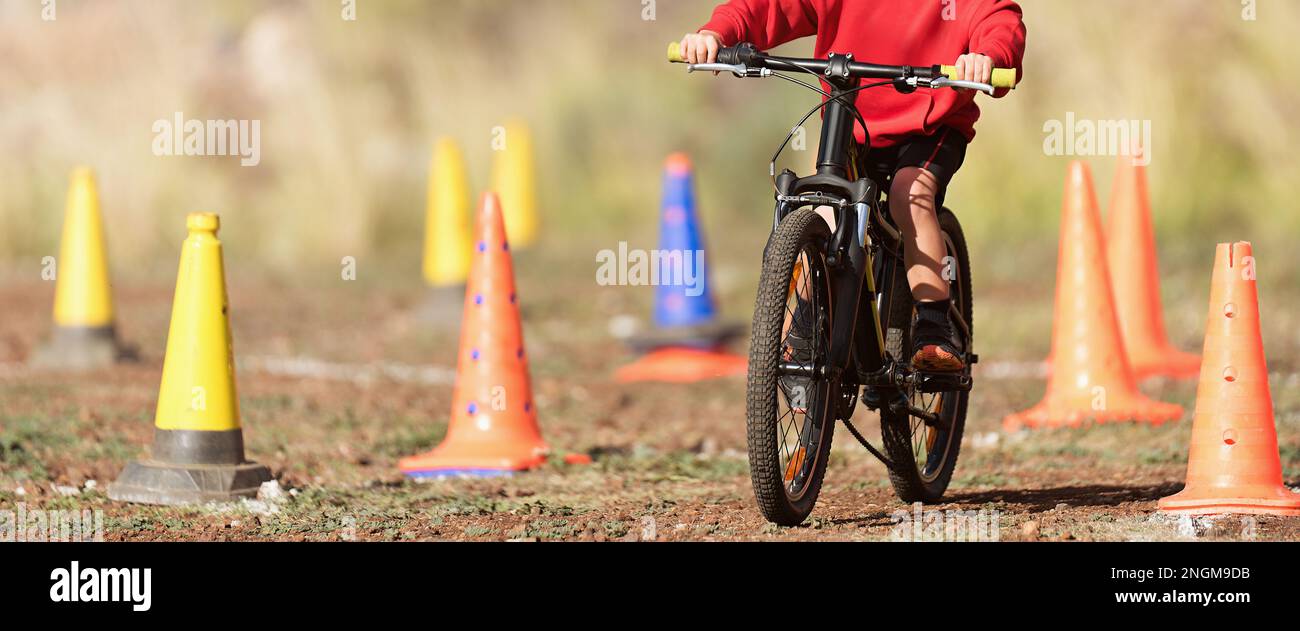 Child riding his bike during a race going around cones along the route