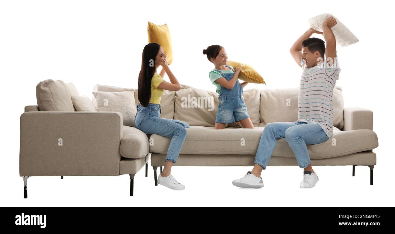 Happy family having pillow fight on comfortable sofa against white background Stock Photo