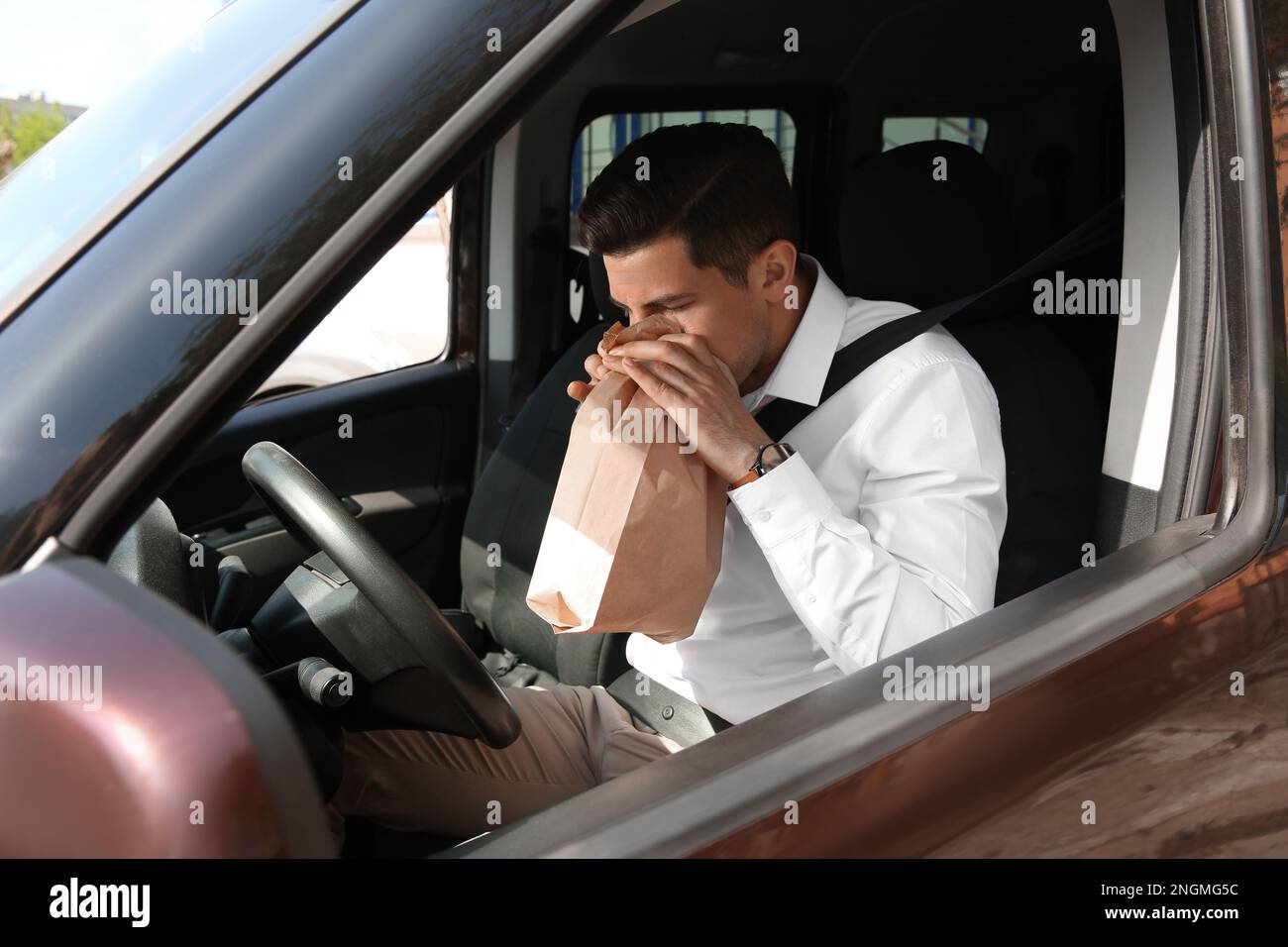 Man with paper bag suffering from nausea in car Stock Photo Alamy