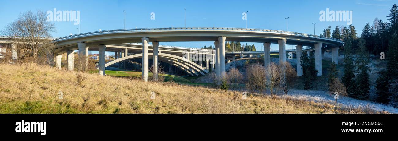 High slip ramp on pillars connecting  new highway called Zakopianka, supported by arc structure in Poland near Skomielna Biala village. Wide panorama. Stock Photo