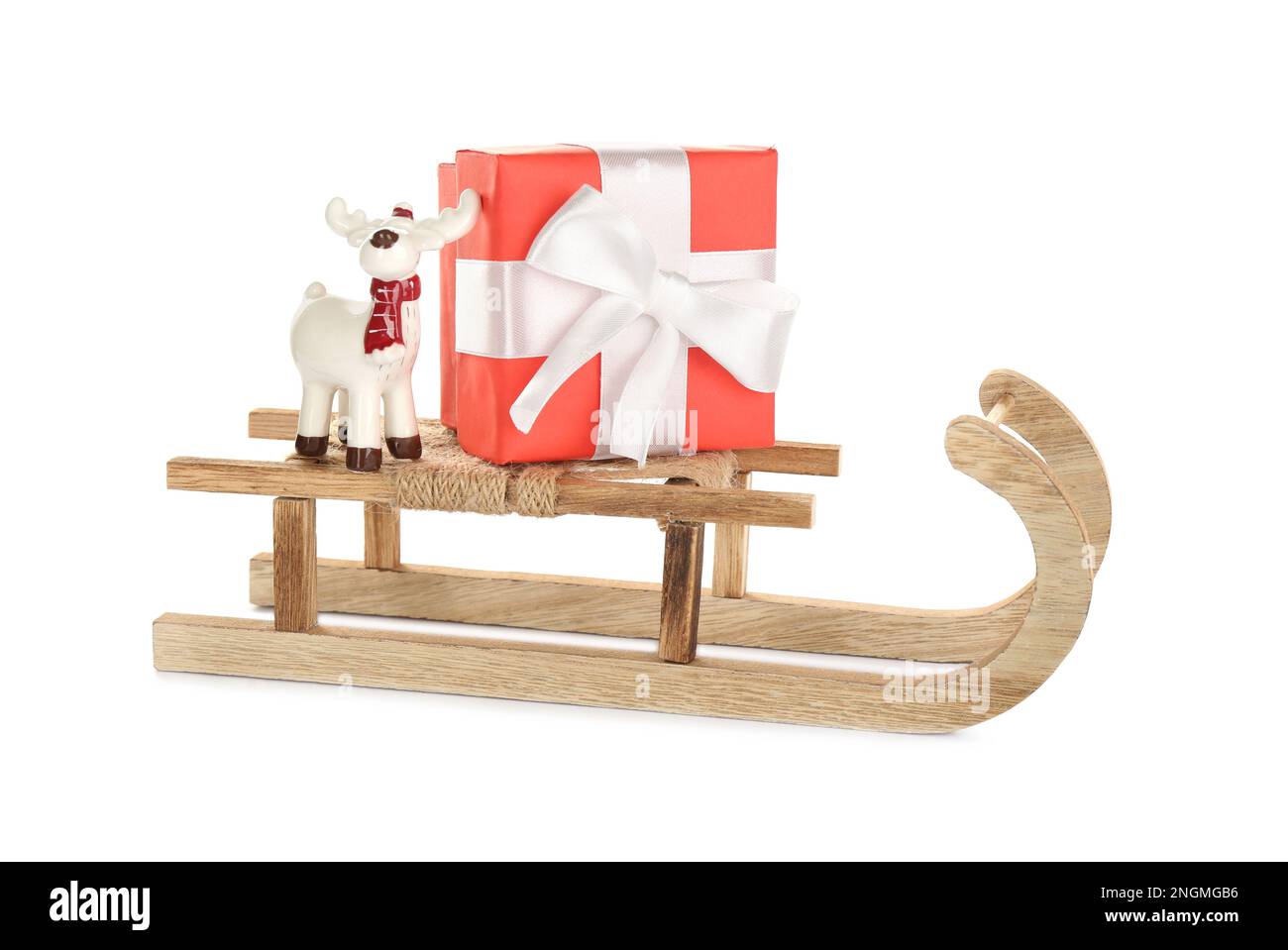 Wooden sleigh with present and decorative reindeer on white background