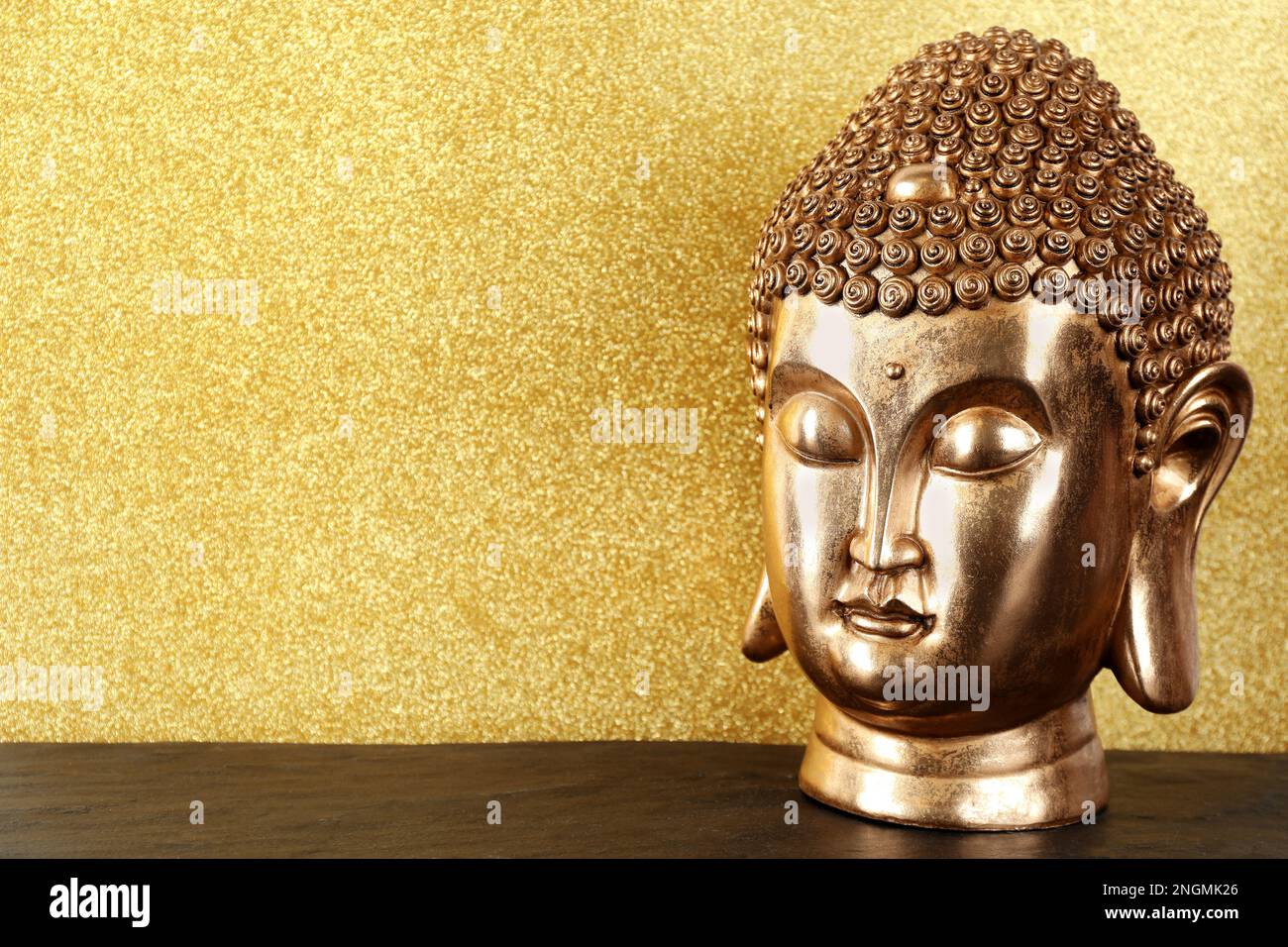 Buddha statue on table against golden background. Space for text Stock Photo Alamy
