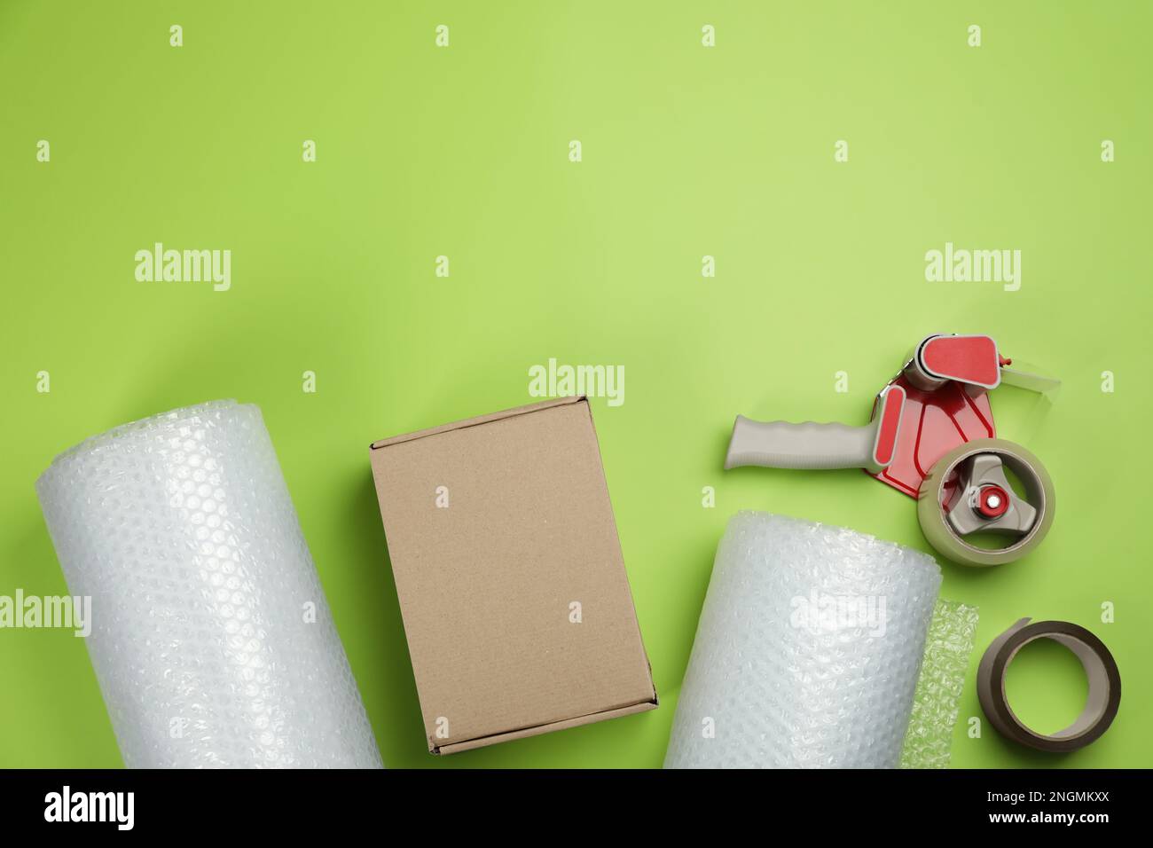 Flat lay composition with bubble wrap rolls on green background, space for text Stock Photo