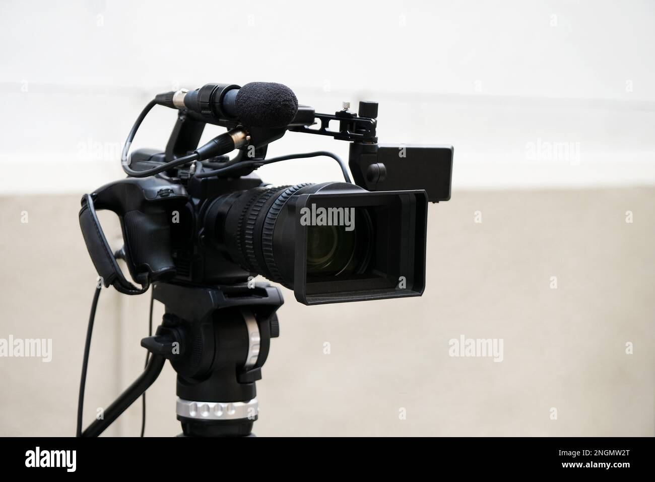 professional digital video or movie camera with microphone on tripod Stock Photo