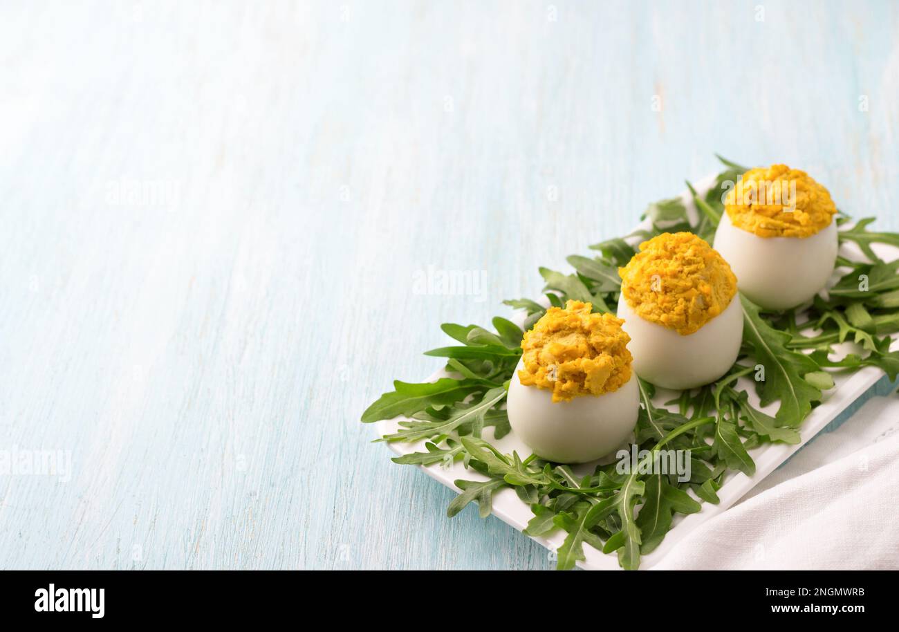 Boiled eggs stuffed with fried onions and turmeric with fresh arugula