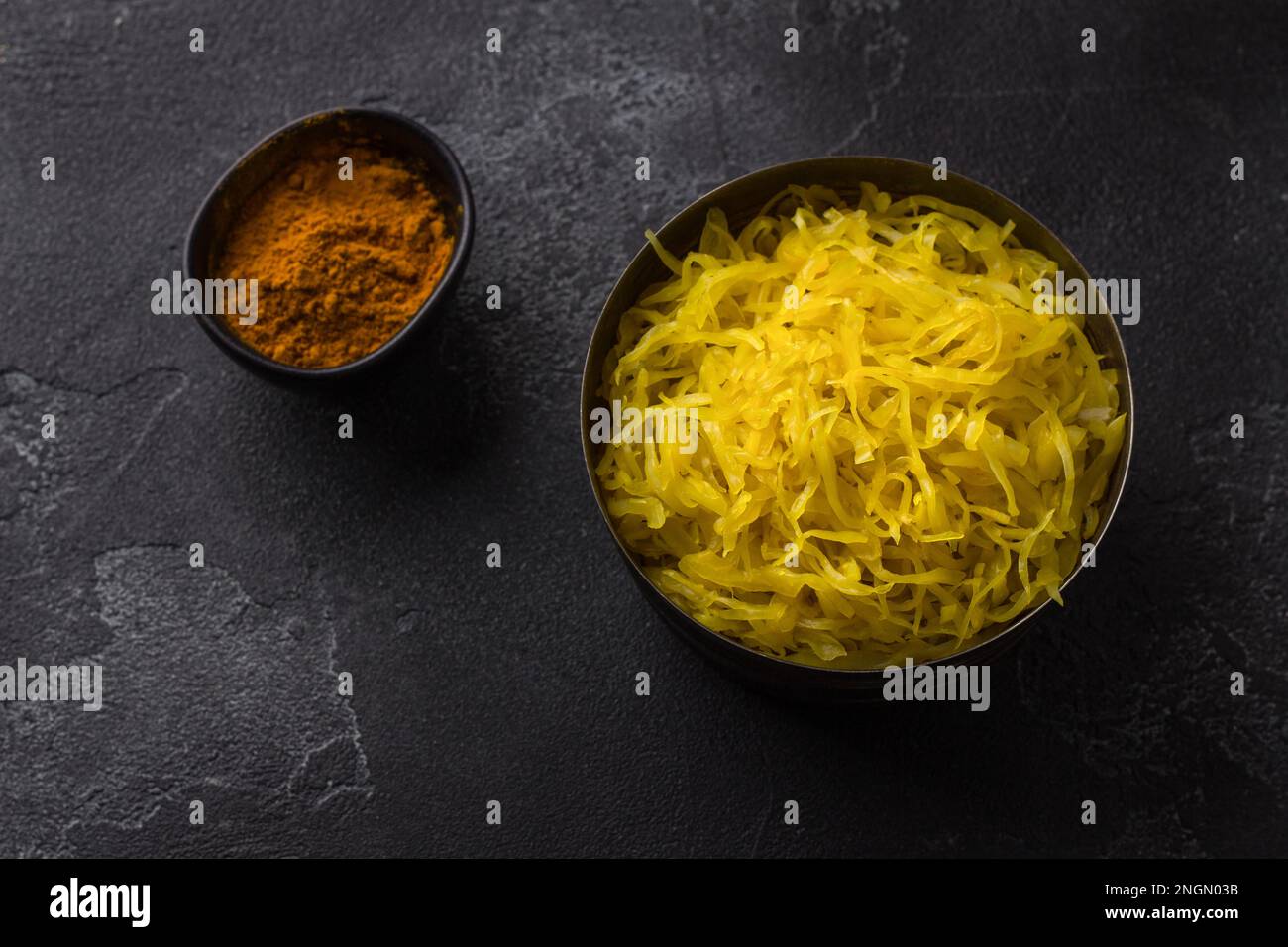Homemade sauerkraut with garlic, onion and turmeric on a dark textured background. healthy fermented food, natural probiotic, vegan food. top view Stock Photo
