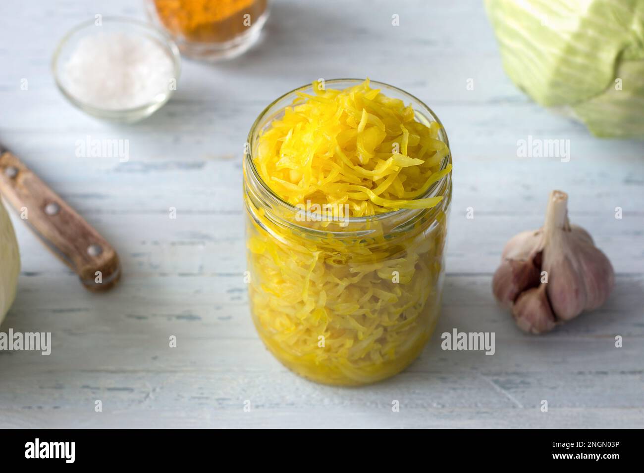 Homemade sauerkraut with garlic, onion and turmeric on a light blue background. healthy fermented food, natural probiotic, vegan food. top view Stock Photo