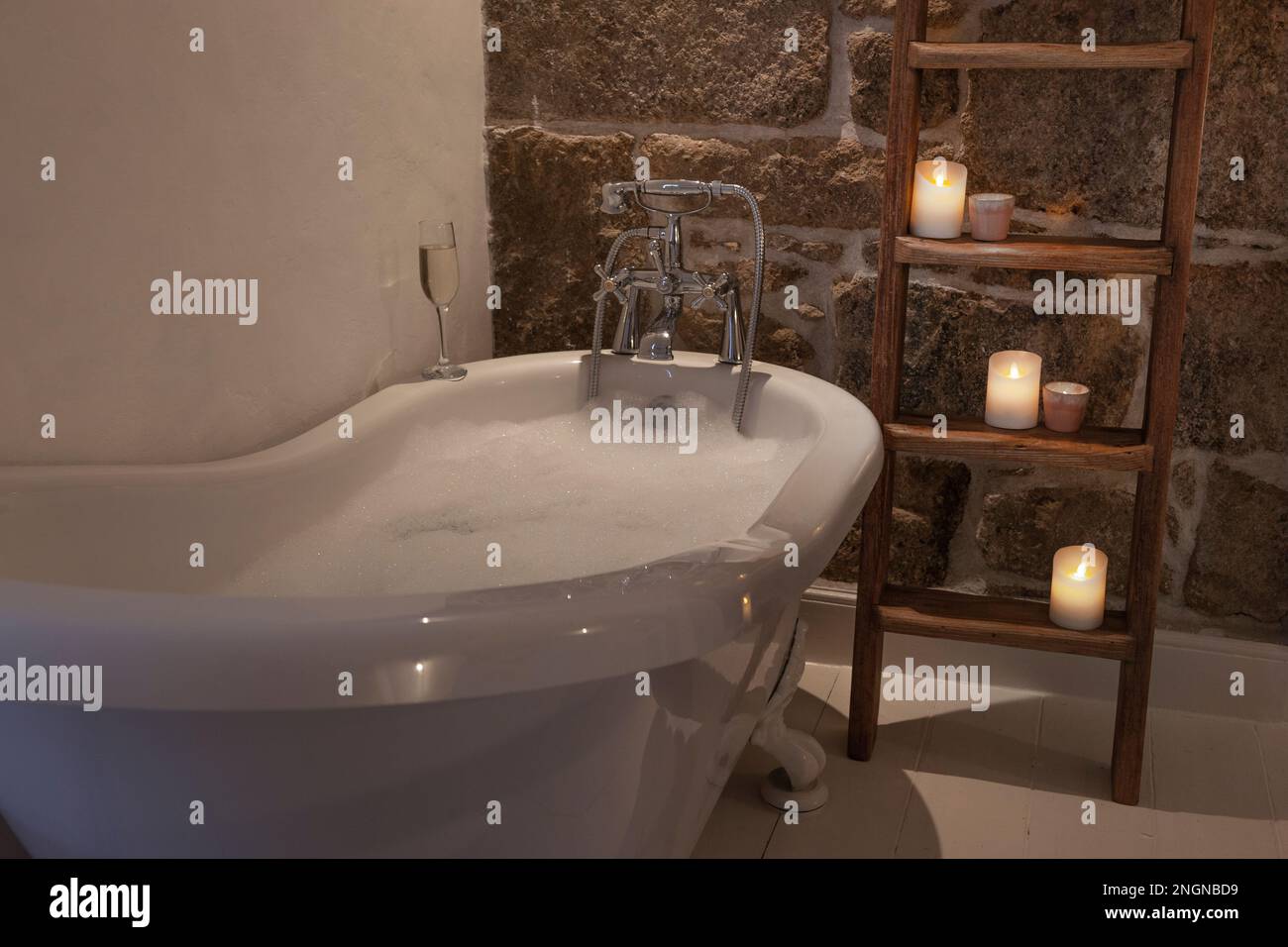 Relaxing bubble bath surrounded by candles in a Cornish cottage Stock Photo
