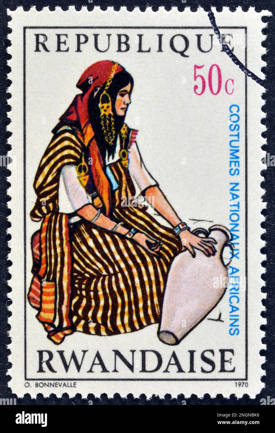 Cancelled postage stamp printed by Rwanda, that shows Woman water carrier, Tunisia, National African costumes, circa 1970. Stock Photo