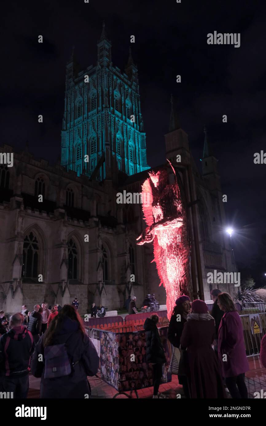 Gloucester, UK. 18th Feb, 2023. People gather around the Knife Angel outside Gloucester Cathedral to remember Holly Gazzard who was murdered by a former boyfriend on this day in 2014. Holly's family have since become campaigners against domestic abuse promoting education on healthy relationships to schools and colleges. The Knife Angel is a 27ft sculpture made of 100,000 blades seized by the Police. Knife Angel is on a national tour to raise awareness of the perils of knife crime. Credit: JMF News/Alamy Live News Stock Photo