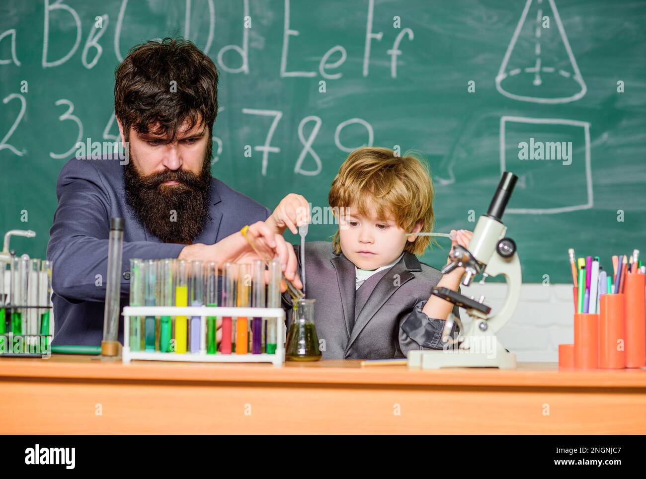 father and son child at school. Chemistry beaker experiment. bearded man teacher with little boy