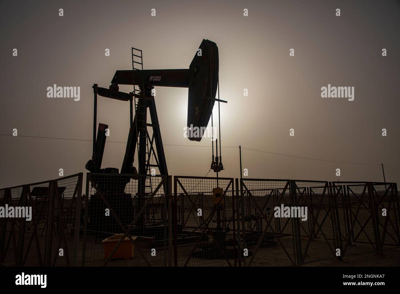 Pumpjack aka oil horse, nodding donkey, oil jack, beam pump raises crude oil in the Bahrain desert at Sakhir on the Persian Gulf. Stock Photo