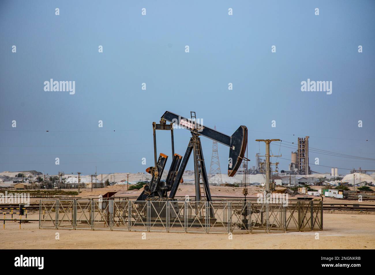 Pumpjack aka oil horse, nodding donkey, oil jack, beam pump raises crude oil in the Bahrain desert at Sakhir on the Persian Gulf. Stock Photo