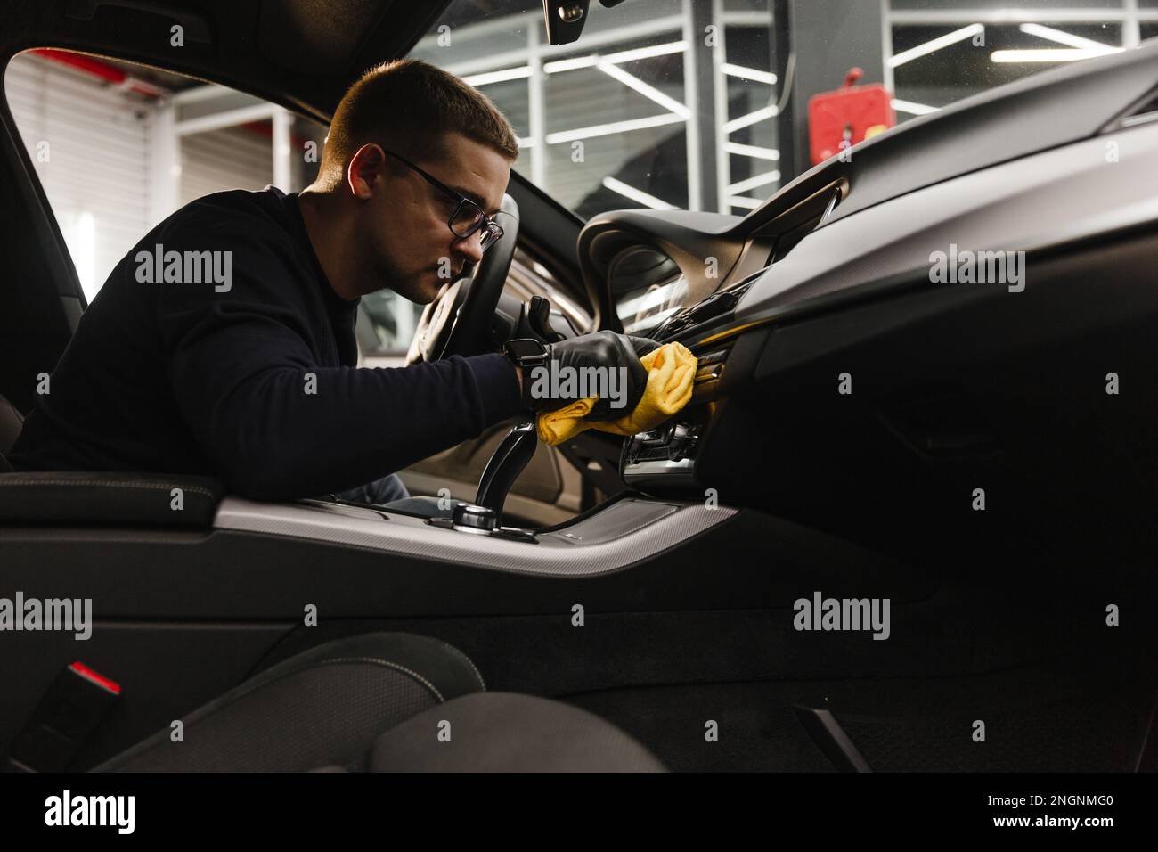 A man cleans a car and dries the interior with a polishing tool Manual