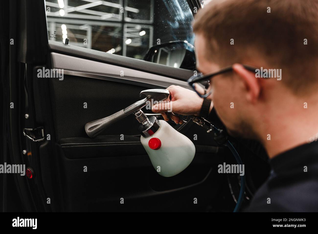 A man cleans a car and dries the interior with a polishing tool Manual