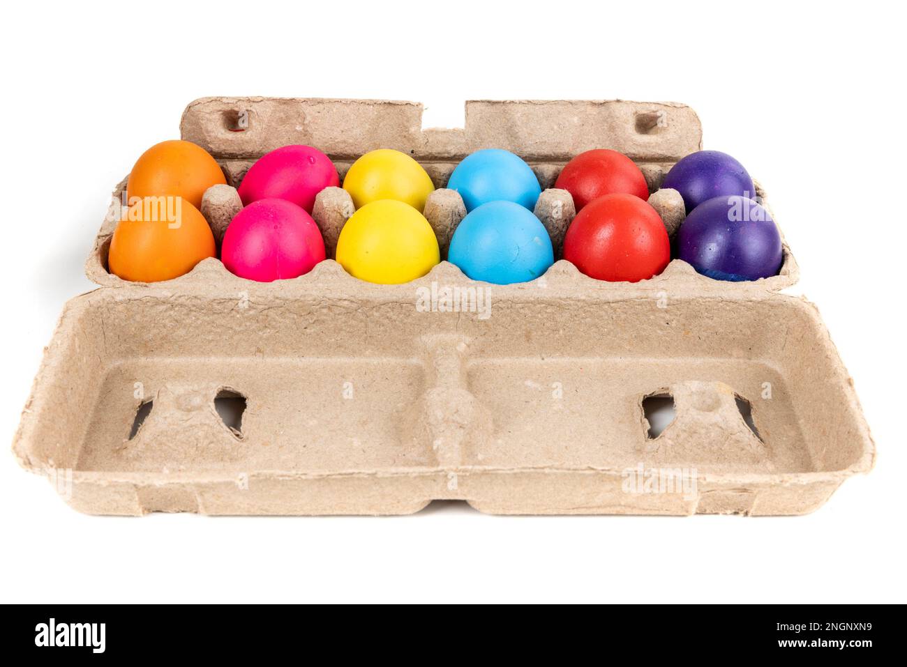 Brightly colored confetti eggs in a brown egg carton, side view Stock