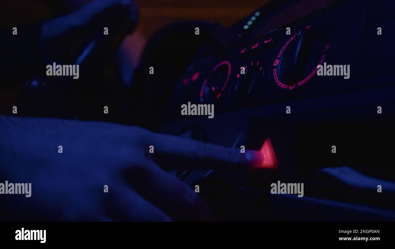 CloseUp Hand Pushing the Flashing Hazard Lights Button in a Car