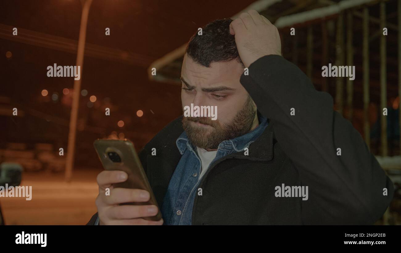 Bearded, Strapping Young Man Scratching His Head in Amazement as He