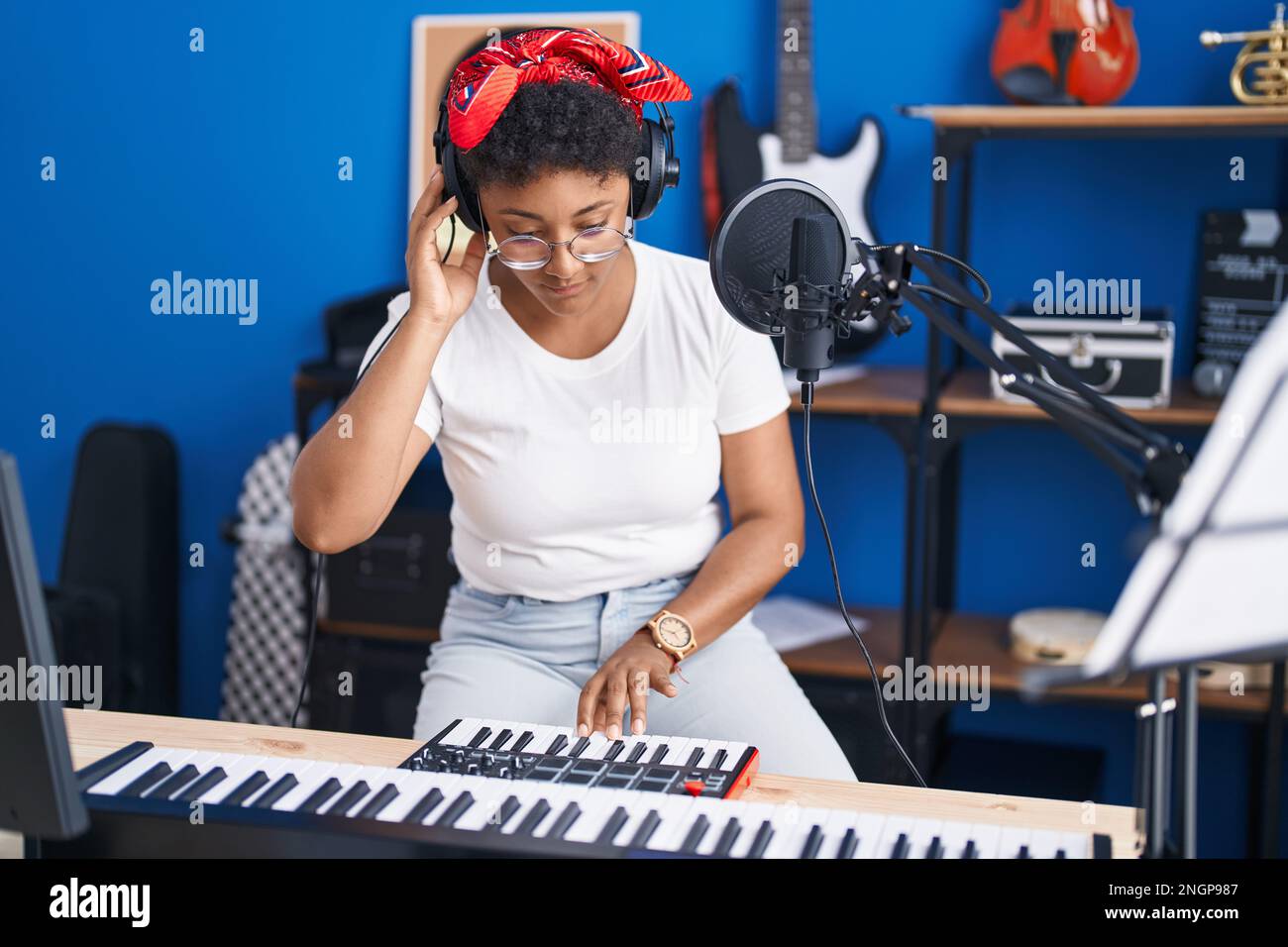 African american woman musician playing piano at music studio Stock Photo