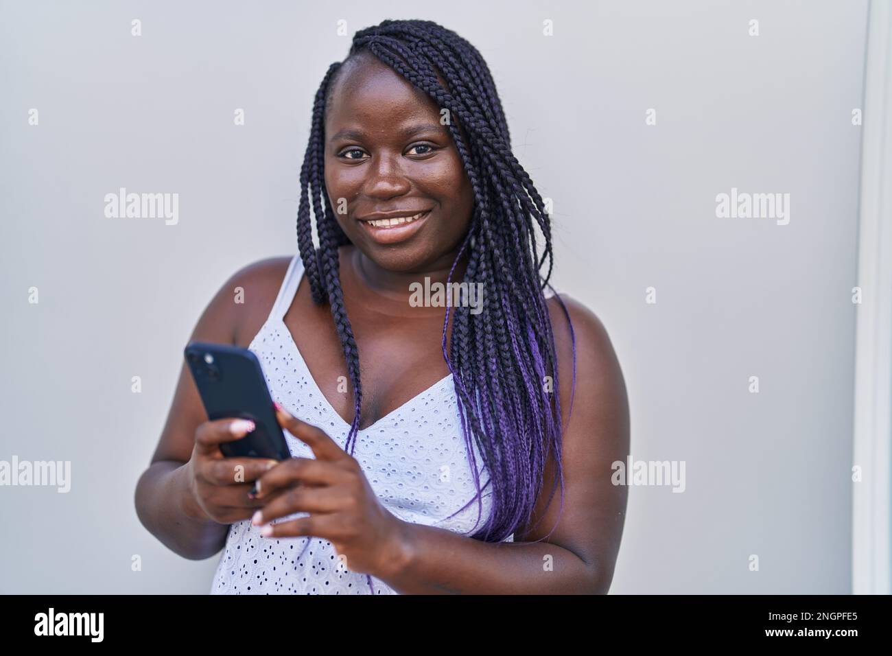 African american woman smiling confident using smartphone over isolated ...