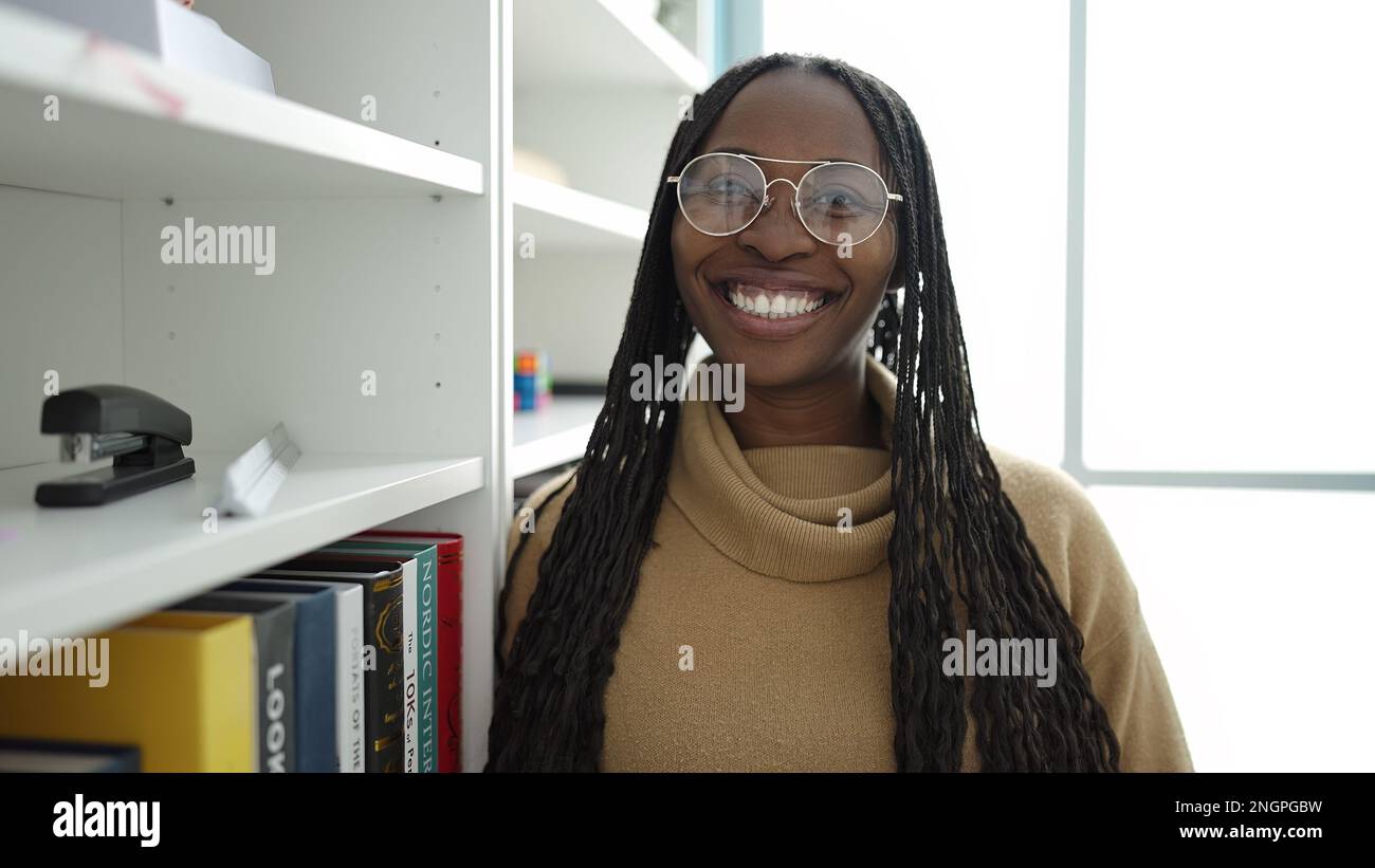 African woman smiling confident at library university Stock Photo - Alamy