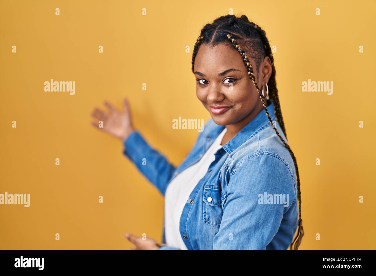 African american woman with braids standing over yellow background ...