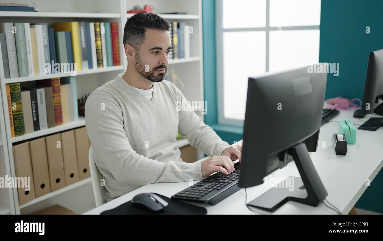 Hispanic Man Using Computer Young hispanic man student using computer studying at library ...