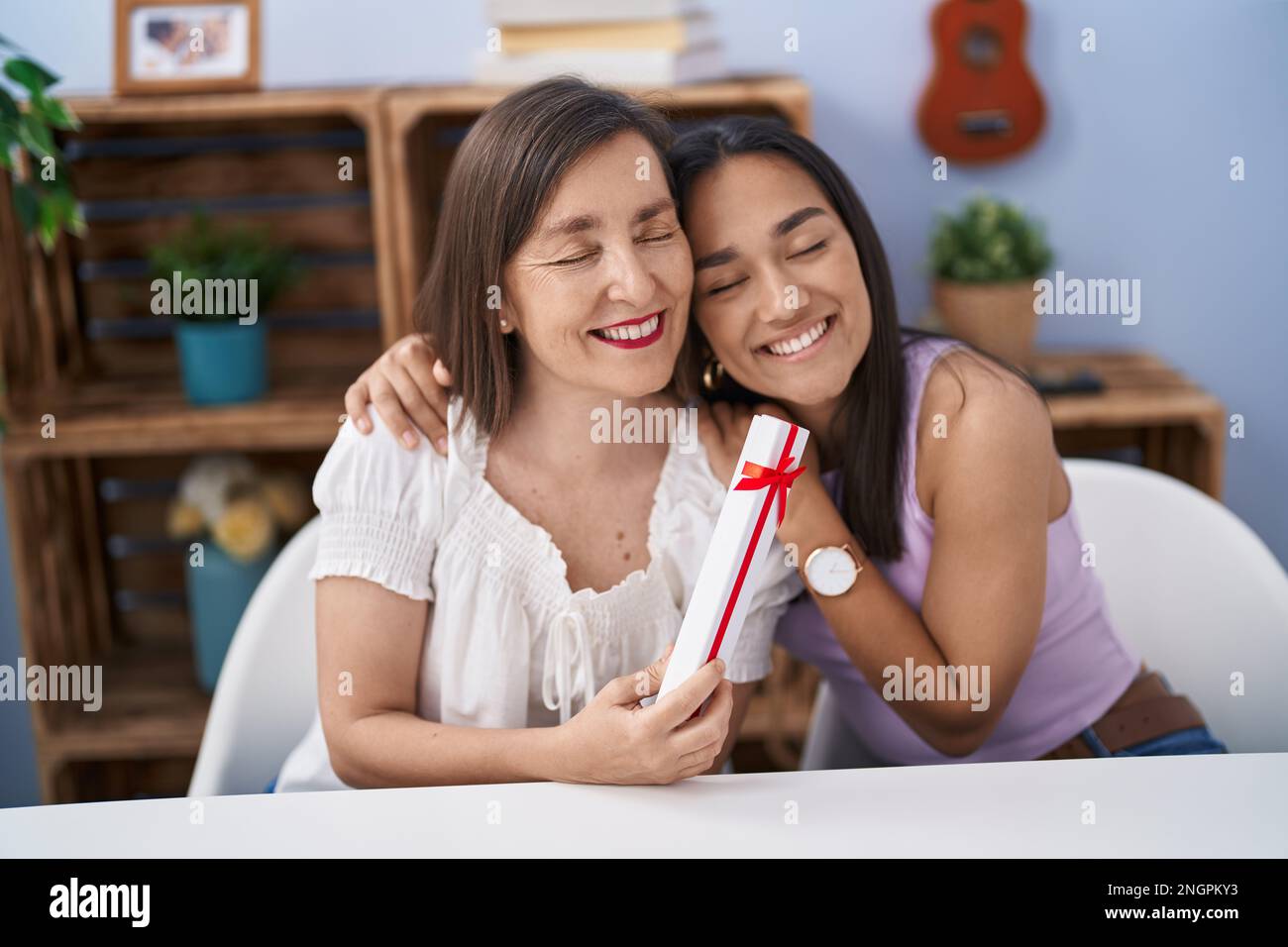 Two women mother and daughter surprise with gift at home Stock Photo — free download