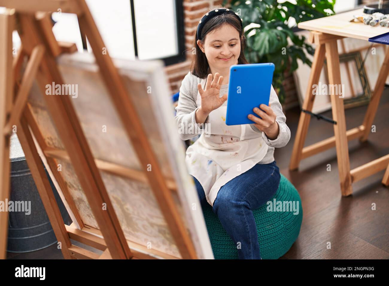 young-woman-with-down-syndrome-artist-having-video-call-drawing-at-art