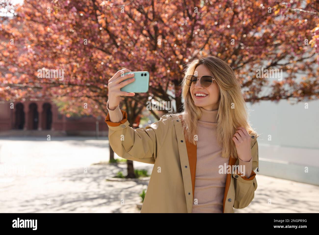 Young woman taking selfie on city street Stock Photo - Alamy