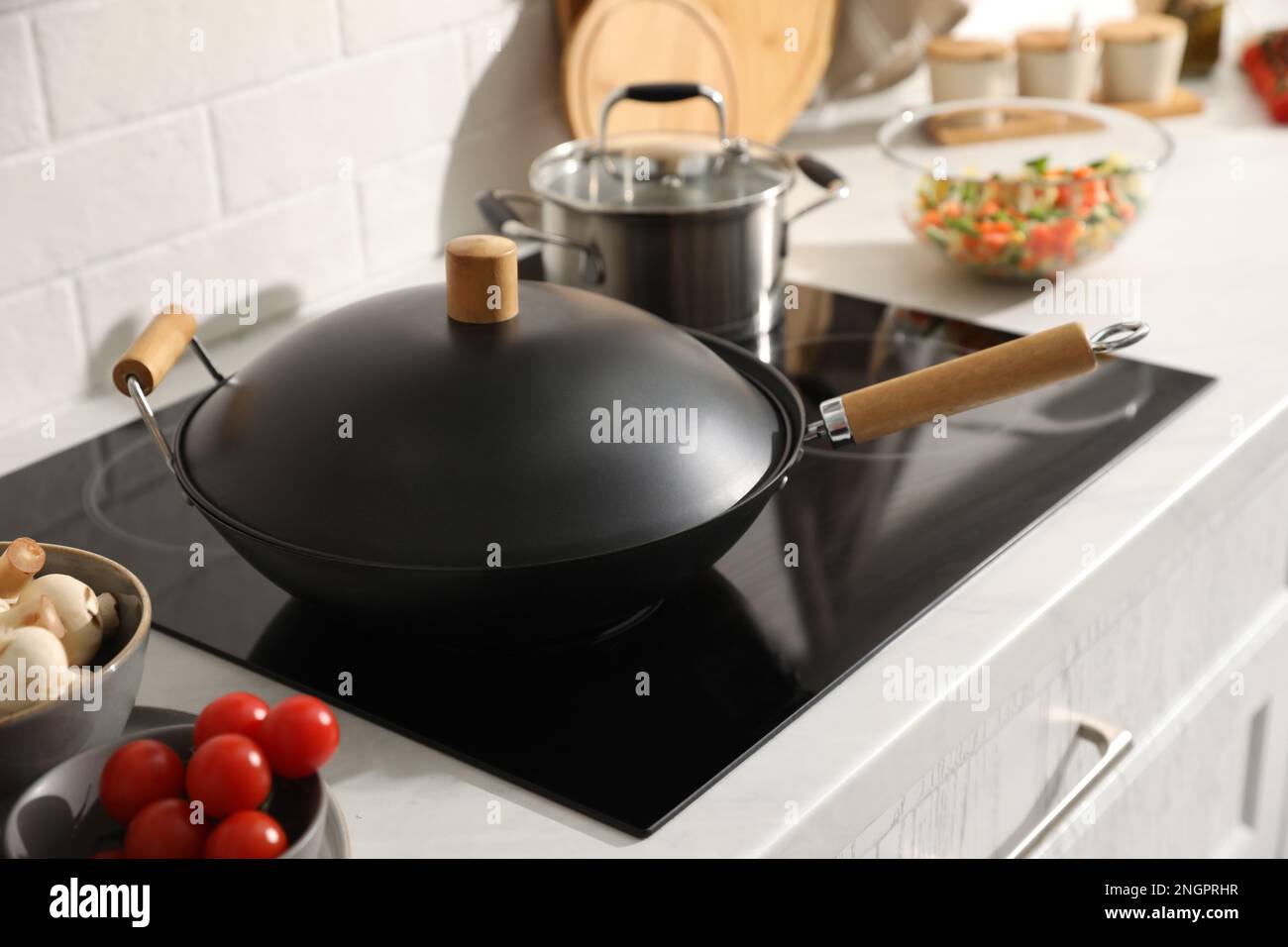 Frying pan with lid on cooktop in kitchen Stock Photo - Alamy