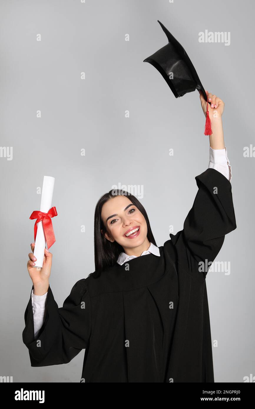 Happy student with graduation hat and diploma on grey background Stock ...