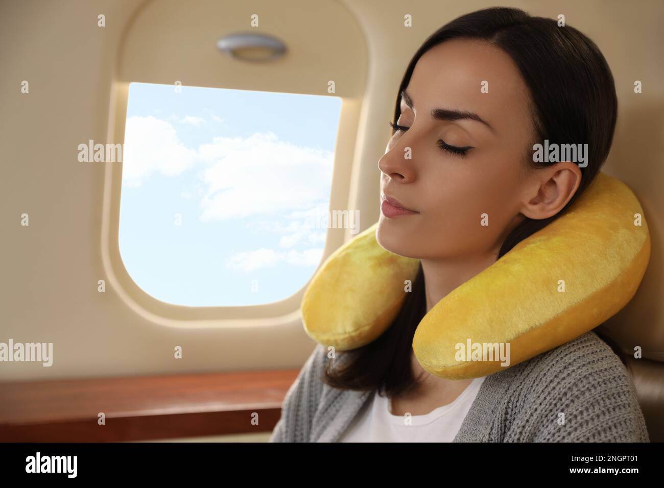 Young woman with travel pillow sleeping in airplane during flight Stock Photo Alamy